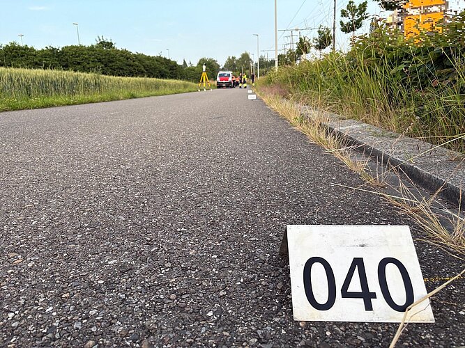 Der Radweg aus der Froschperspektive, mit einem Beweis-Nummernschild 040 im Vordergrund. 